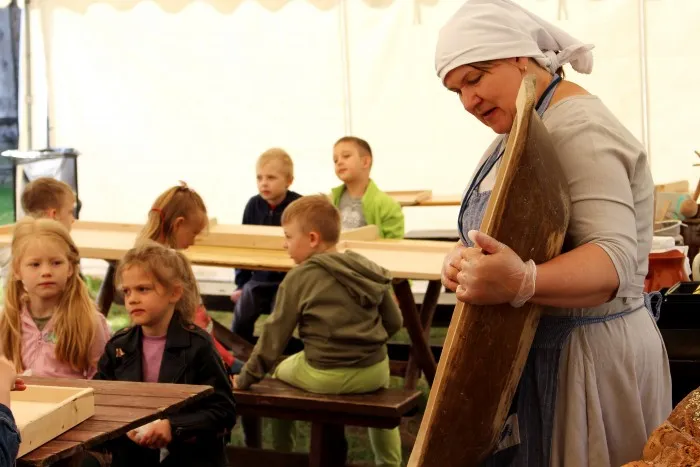 Warsztaty rzemieślnicze w skansenie, dzieci lepiące z gliny, wypiek chleba