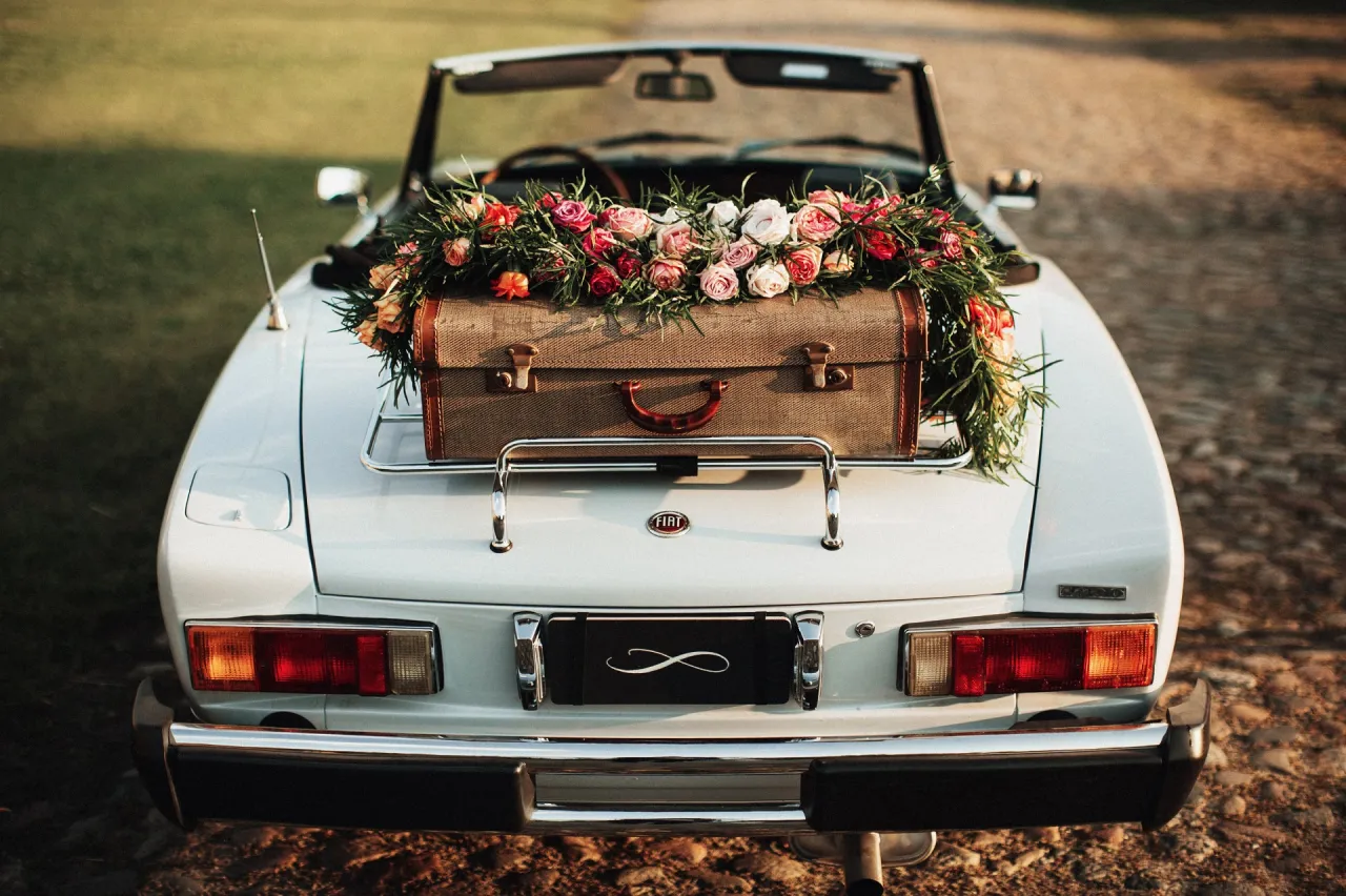 klasyczny samoch&oacute;d do ślubu udekorowany kwiatami