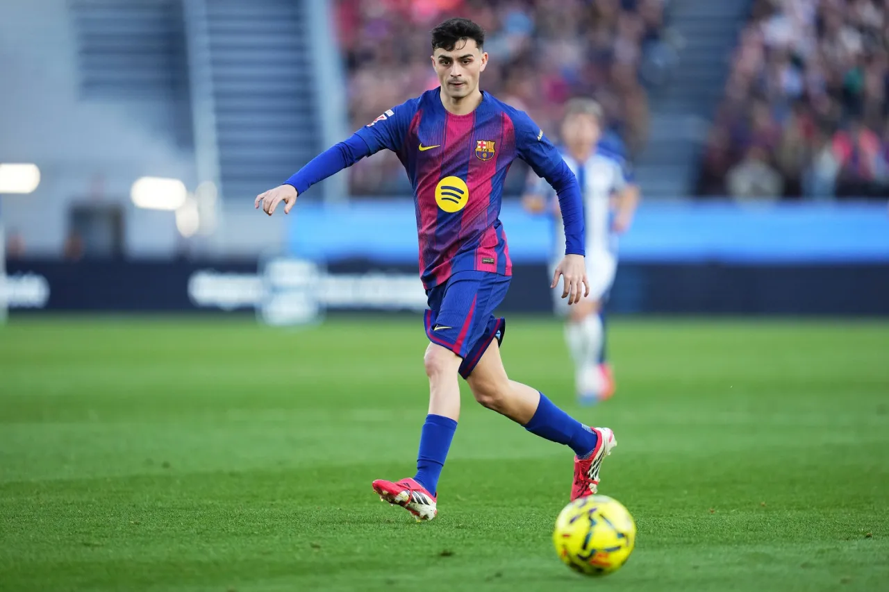 Młody piłkarz w koszulce Barcelony biegnie z piłką. Zastanawiasz się, ile kilometr&oacute;w przebiega piłkarz podczas meczu?