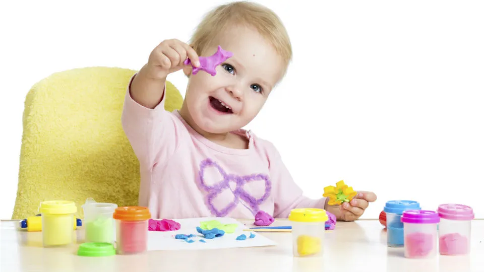 dziecko bawiące się masą plastyczną przy stoliku