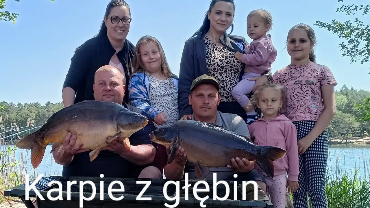 Dzieci wędkujące z rodzicami nad jeziorem