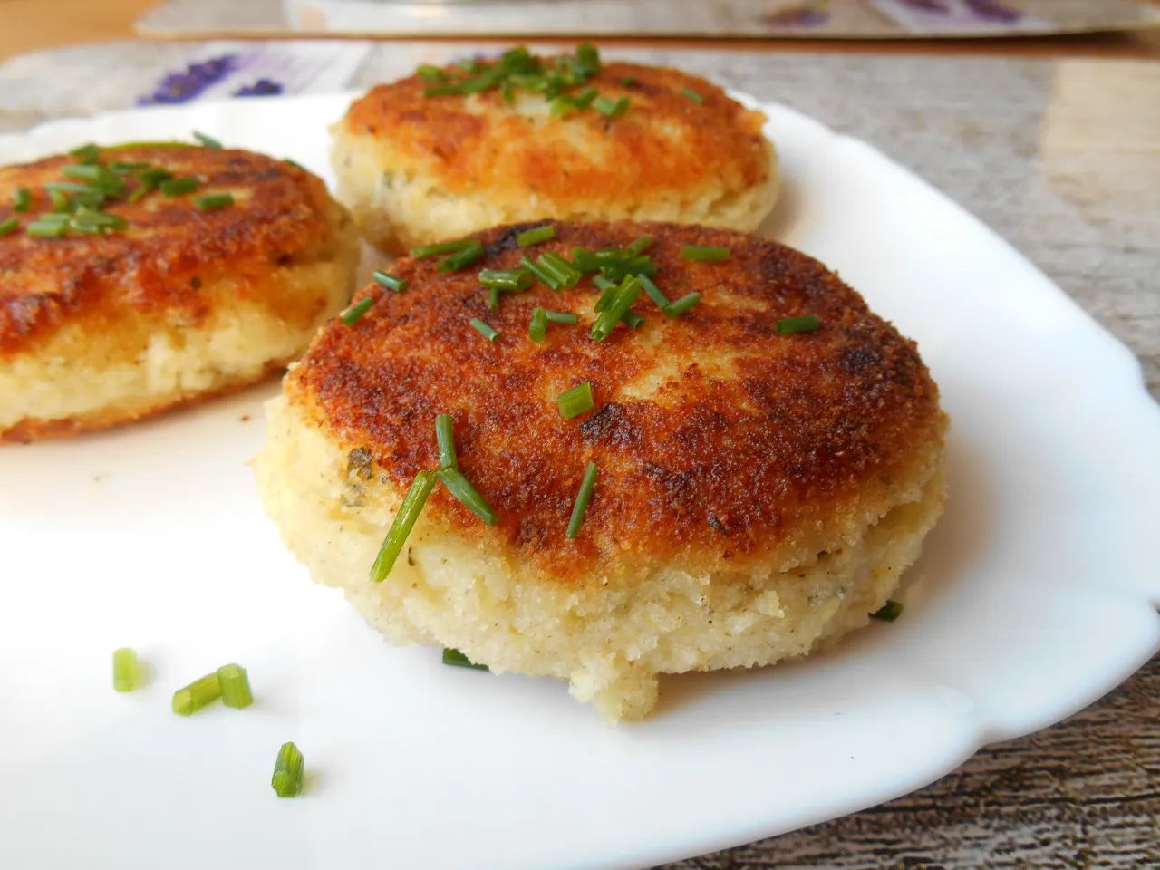 Placuszki z kaszy manny, idealne co zamiast ziemniaków do kotleta. Złociste, posypane szczypiorkiem.