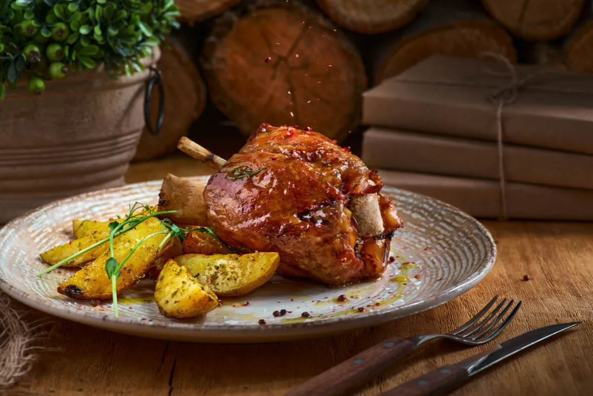 Apetyczna golonka pieczona z ziemniakami, idealna po peklowaniu.