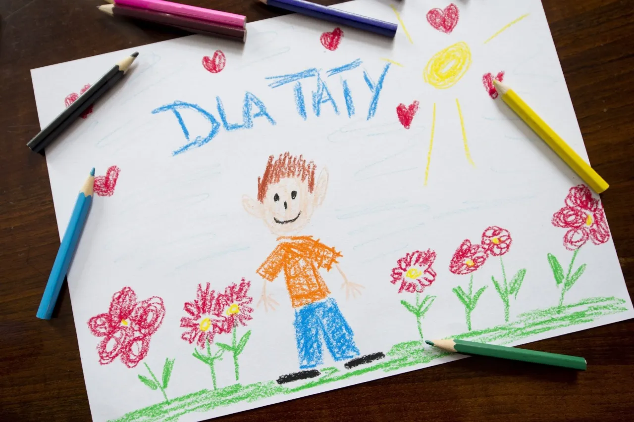 dziecko wręczające laurkę tacie na Dzień Ojca