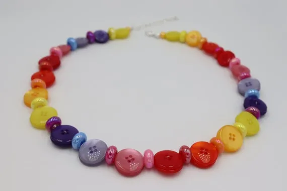 Kolaż r&oacute;żnych styl&oacute;w naszyjnik&oacute;w z guzik&oacute;w: monochromatyczny, kolorowy, efekt grona