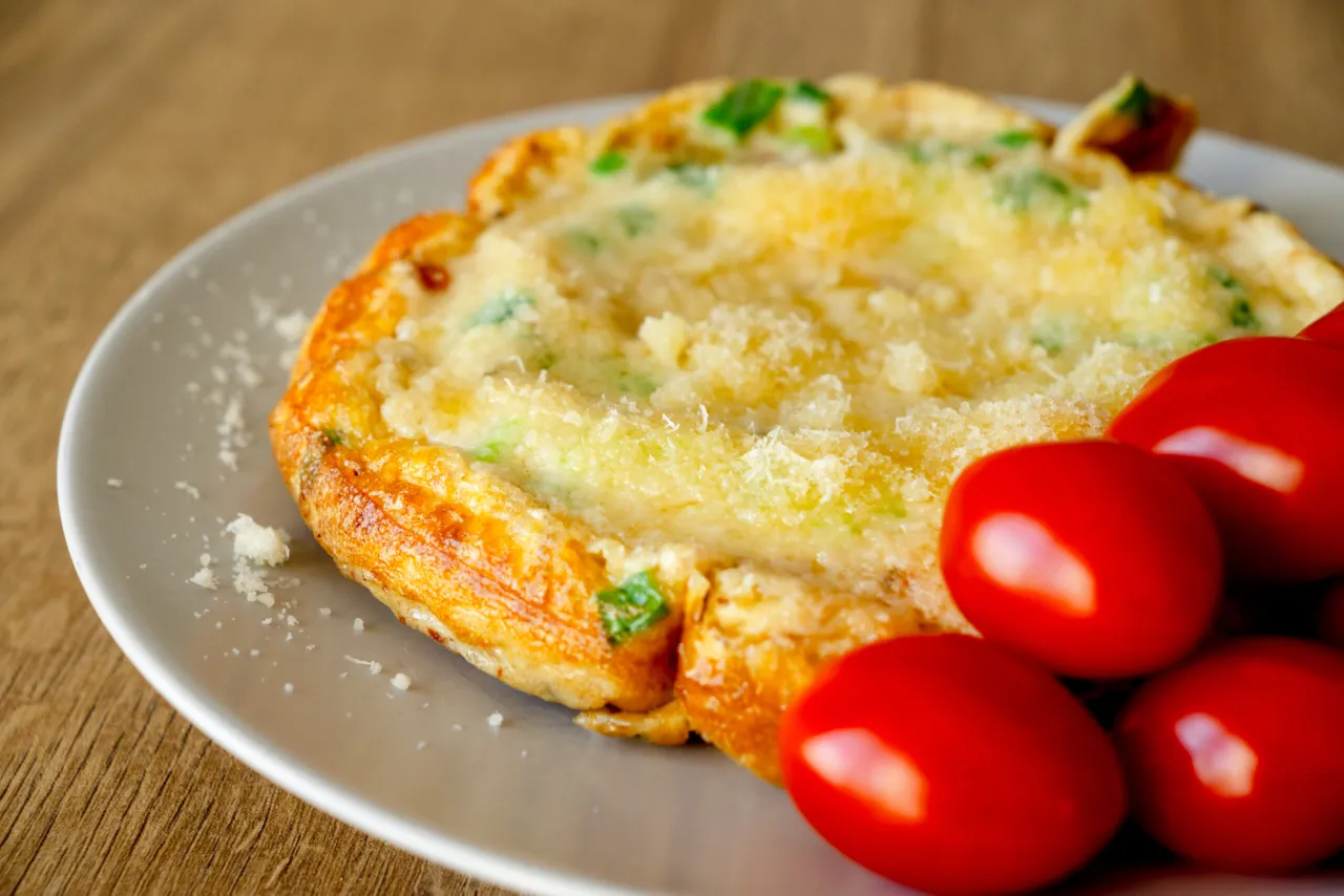 Jajecznica z zieloną cebulką i parmezanem, podana z pomidorkami koktajlowymi. Idealne śniadanie dla cukrzyka.