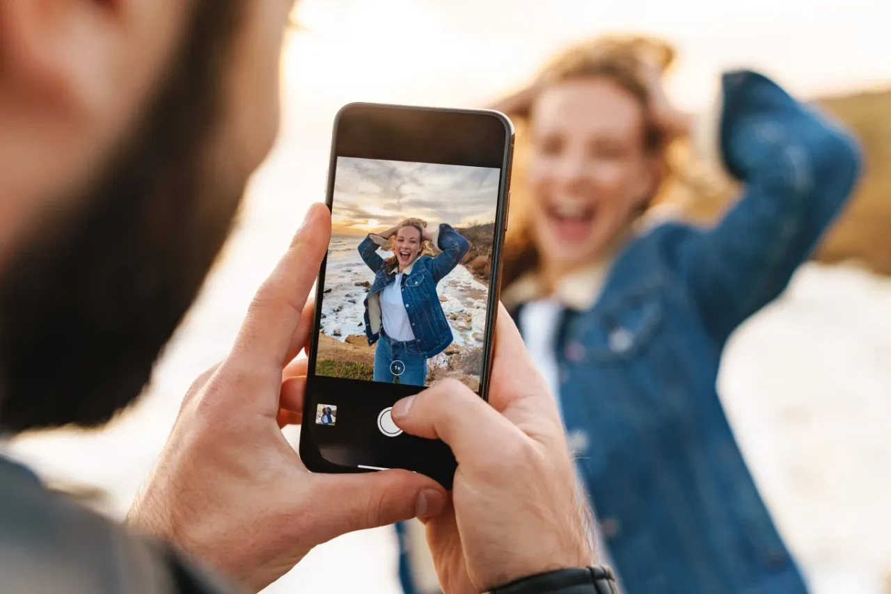 osoba edytująca zdjęcie na smartfonie z elementami AI