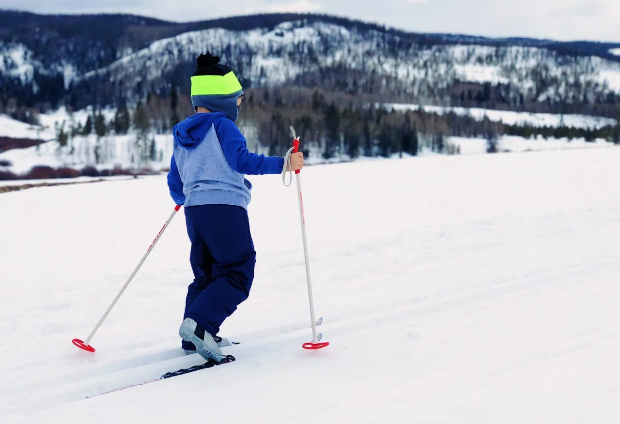Osoba początkująca na nartach biegowych w odpowiednim stroju
