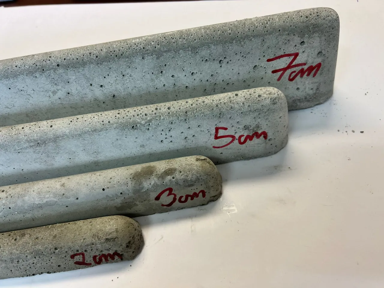 R&oacute;żne rozmiary listew dystansowych pod zbrojenie, oznaczone 7cm, 5cm, 3cm i 2cm, gotowe do użycia.