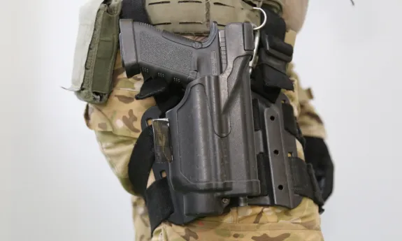 Osoba z bronią palną w kaburze, symbolizująca ochronę osobistą