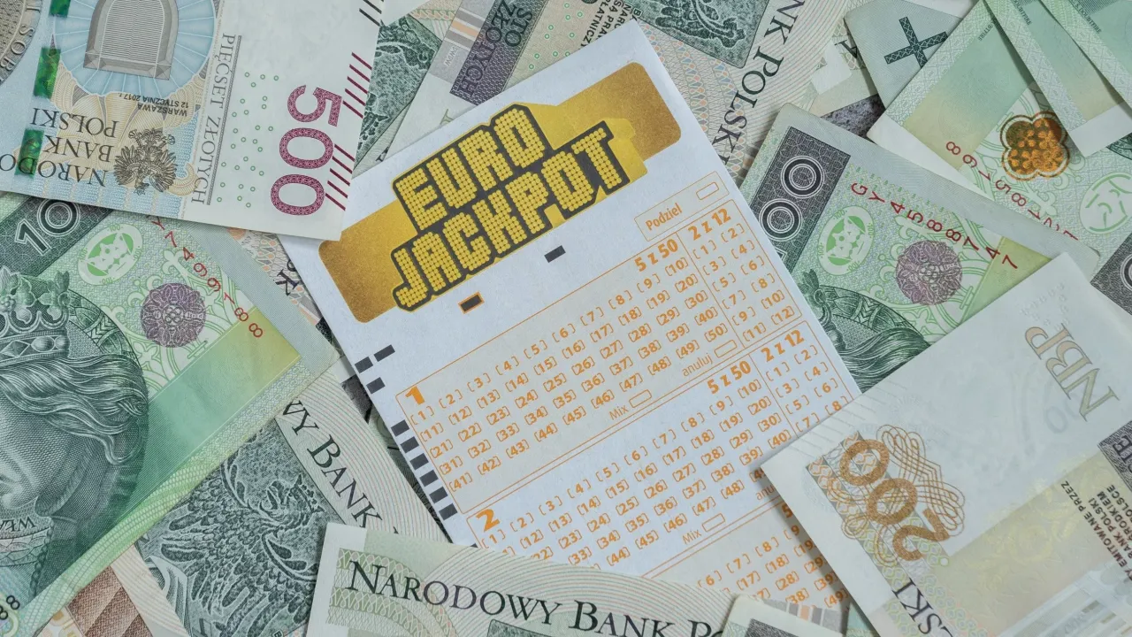 Kupon Eurojackpot leży na stosie polskich banknot&oacute;w. Zastanawiasz się, eurojackpot ile za 2 z 12?