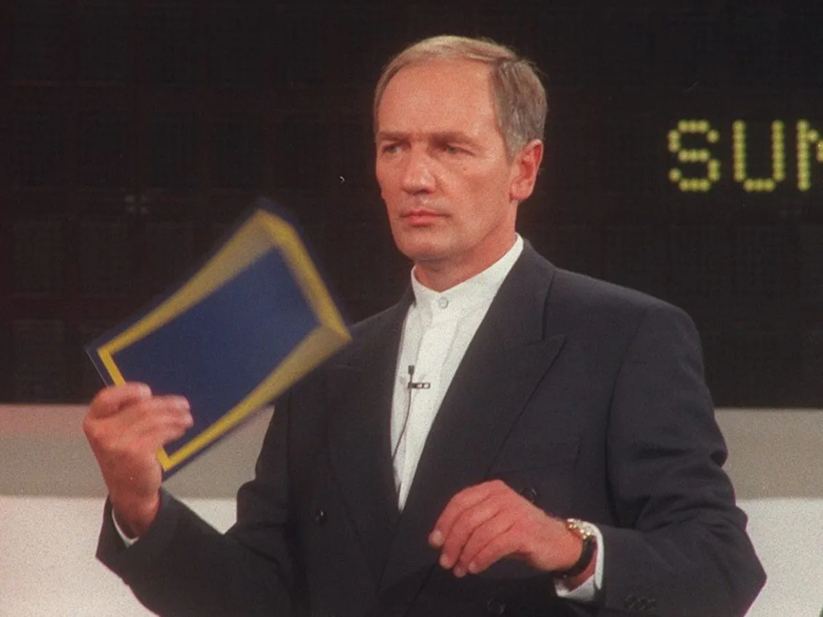 Prowadzący Familiadę od kiedy trzyma niebieską kartkę z ż&oacute;łtą ramką.