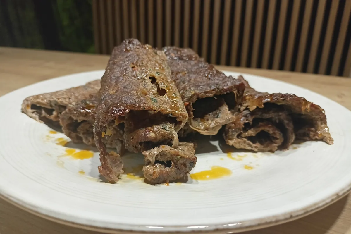 Soczysta wołowina do kebaba, zwinięta w rolady, leży na talerzu, gotowa do podania.