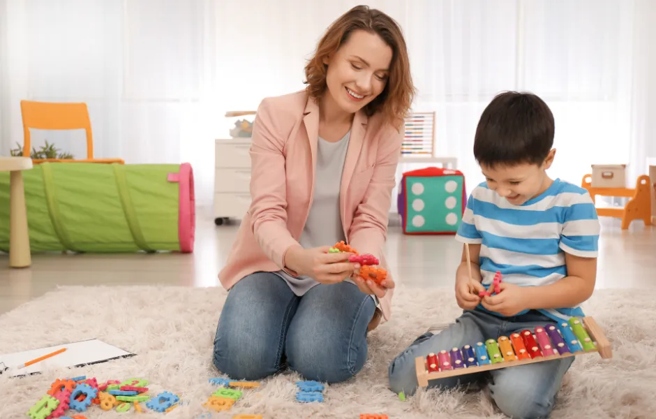 dziecko z autyzmem bawiące się klockami sensorycznymi z rodzicem