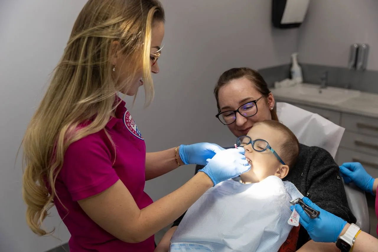 Dentysta bada pacjenta, skupiając się na dziąsłach