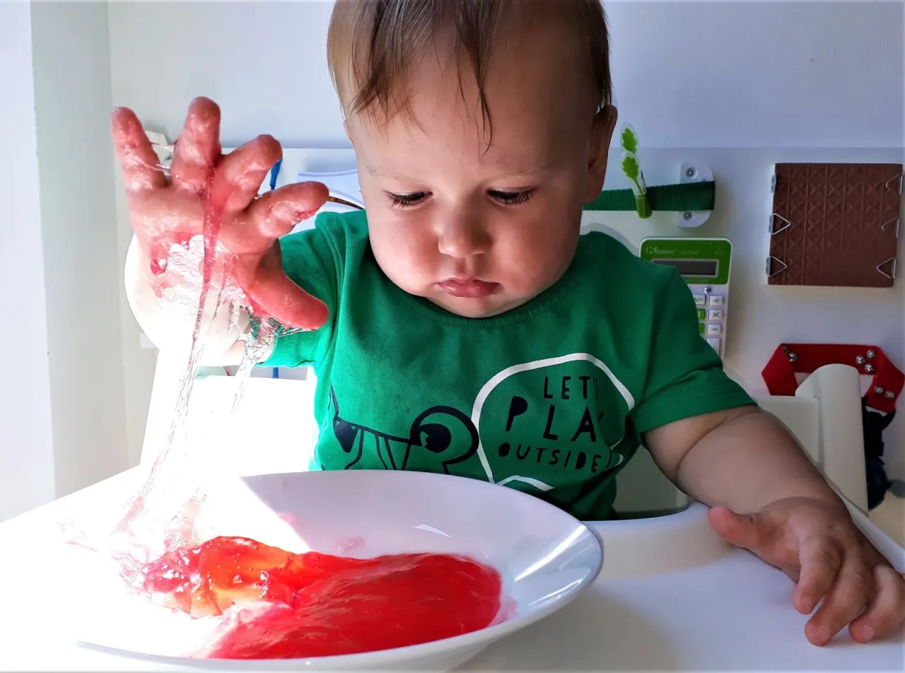 dziecko bawi się kolorowym kisielem