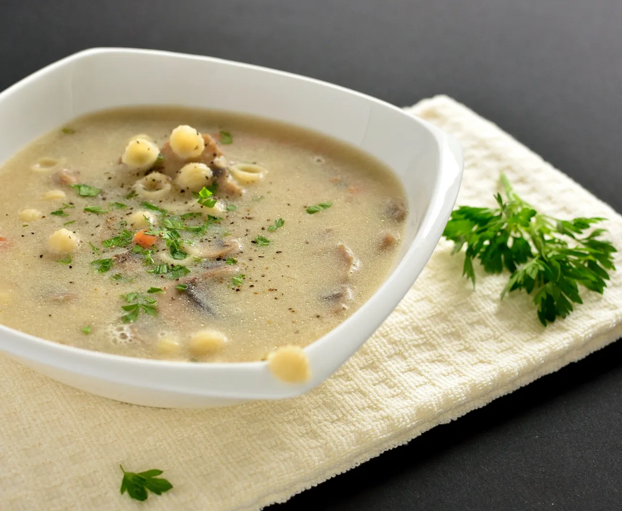 zupa pieczarkowa z makaronem w misce posypana natką