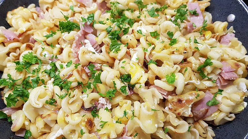 leckere Schinkennudeln in einer Pfanne mit Petersilie garniert
