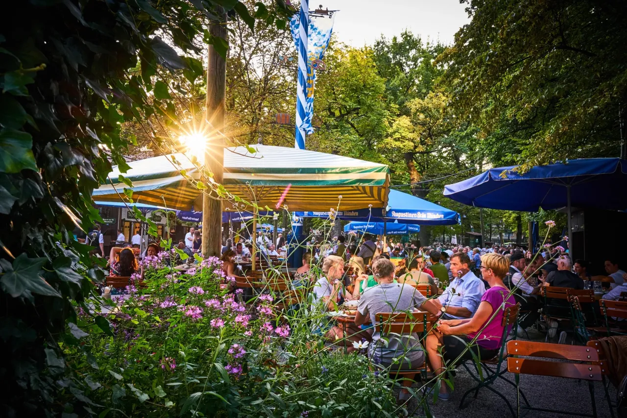 Sonniger Biergarten in M&uuml;nchen mit Personal und G&auml;sten