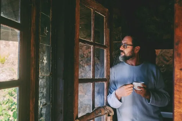 osoba pijąca herbatę i patrząca przez okno w spokoju
