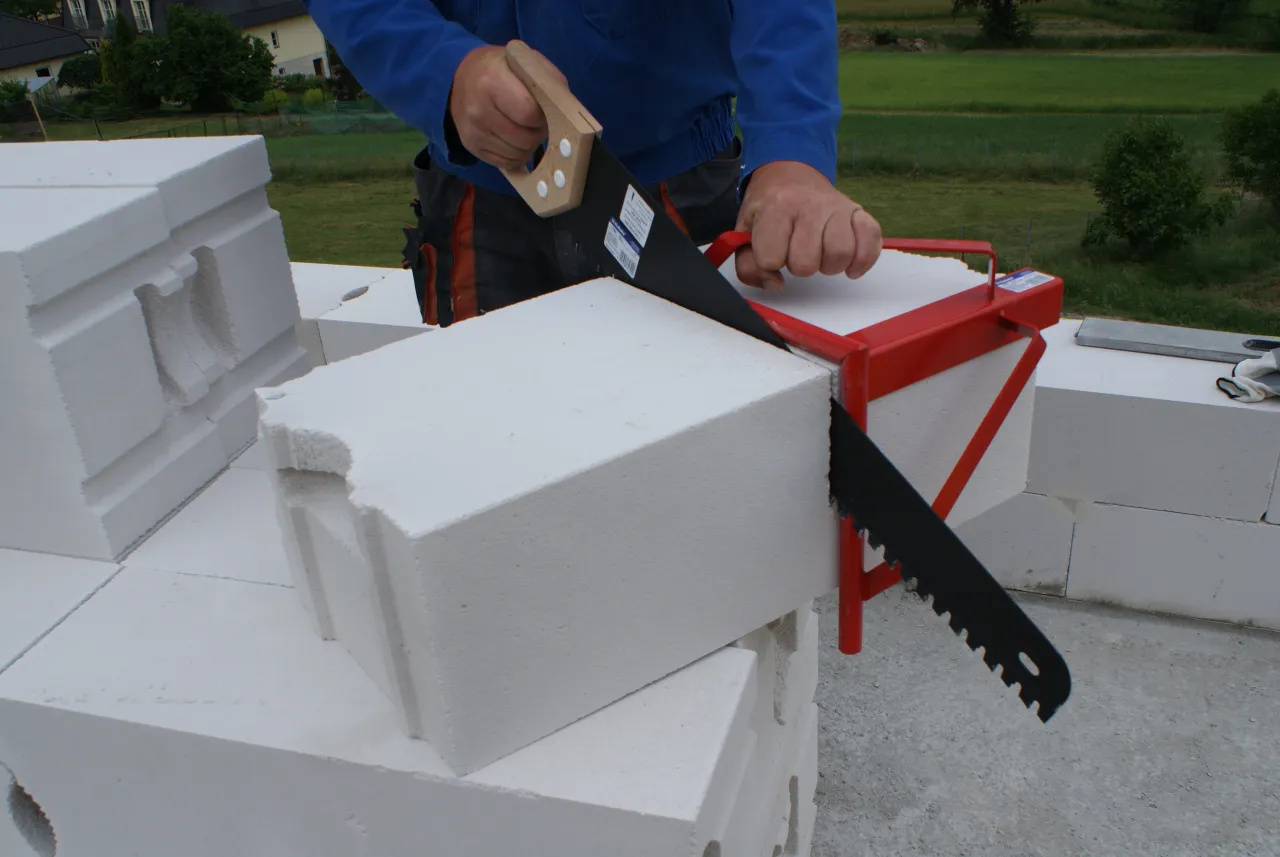 Ręczna piła z prowadnicą tnie pustak. To prosty sposób, jak zrobić piłę do cięcia pustaków, by uzyskać precyzyjne cięcia.