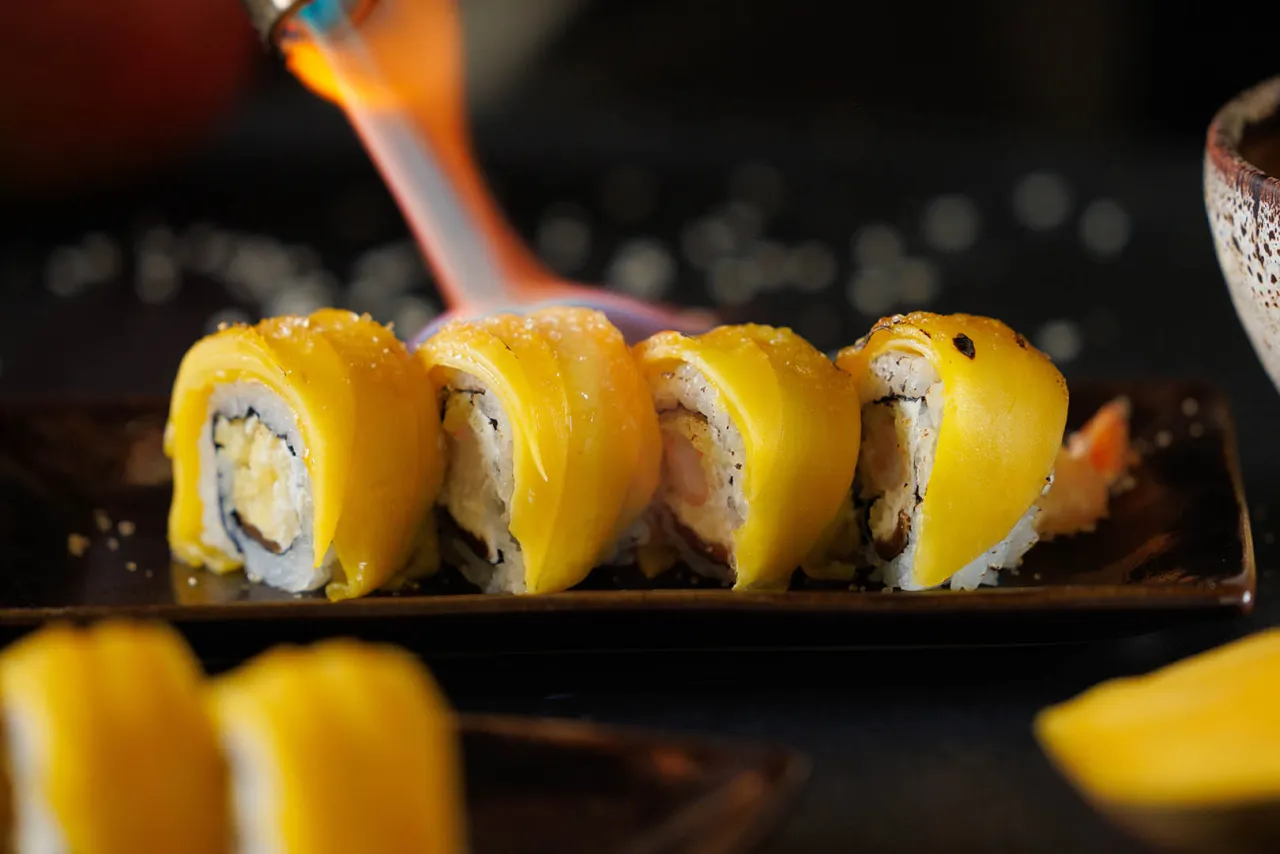 Roladki sushi z mango, delikatnie przypalane palnikiem, tworzą apetyczną kompozycję.