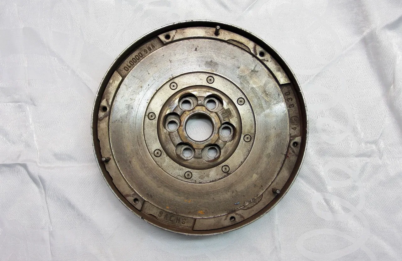 Zużyte koło dwumasowe, objawy przy gaszeniu silnika to stukanie i wibracje. Widoczny element to koło zamachowe.