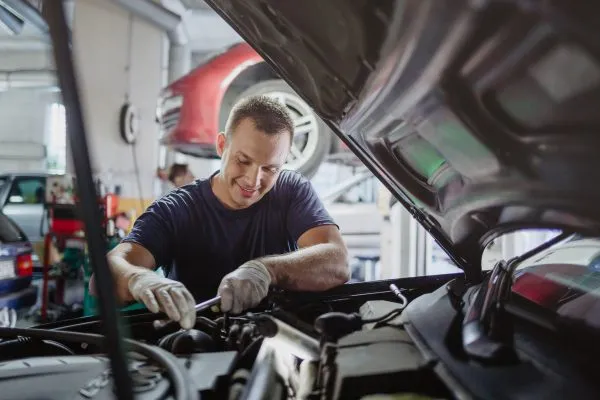 warsztat tuningowy wnętrze, profesjonalny mechanik przy samochodzie