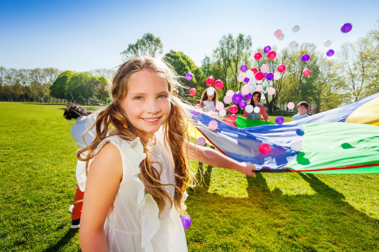 dzieci bawiące się chustą animacyjną na świeżym powietrzu