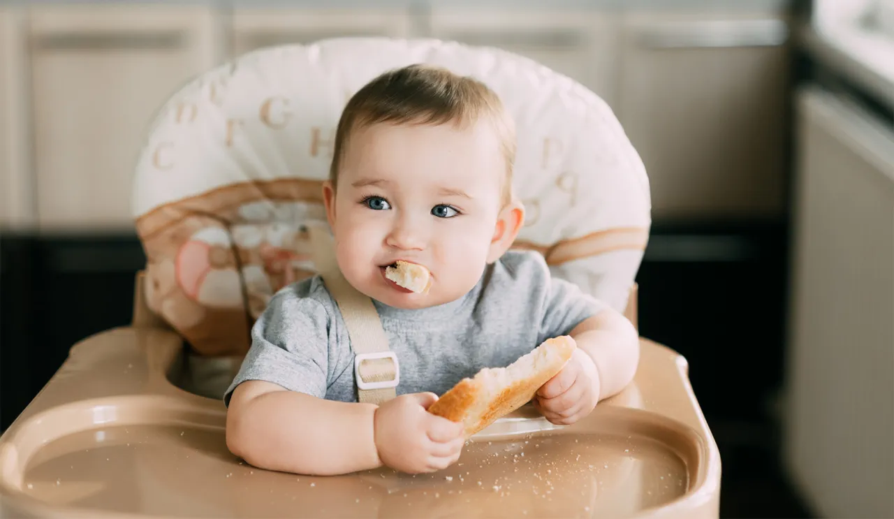Niemowlę jedzące chleb z masłem