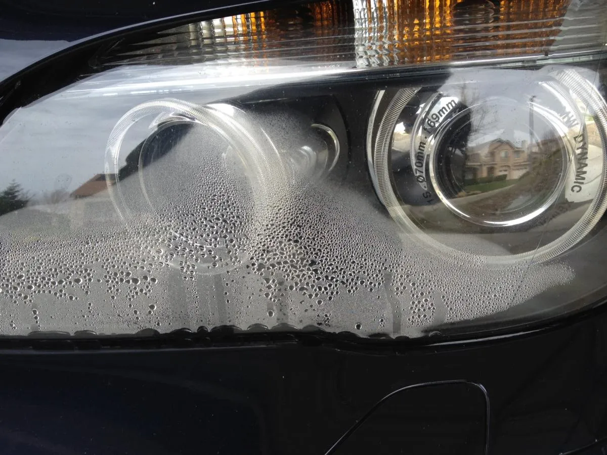 Parujące reflektory LED w nowym aucie, pokryte licznymi kropelkami wody.
