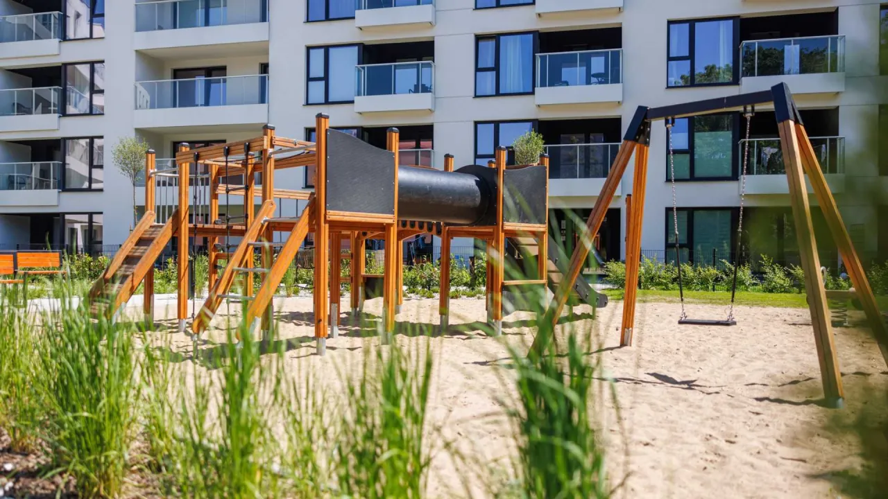 nowoczesny plac zabaw przy bloku ogrodzony