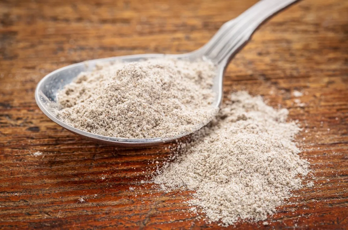Łyżka z krupczatką, która nie jest mąką ziemniaczaną, na drewnianym blacie.