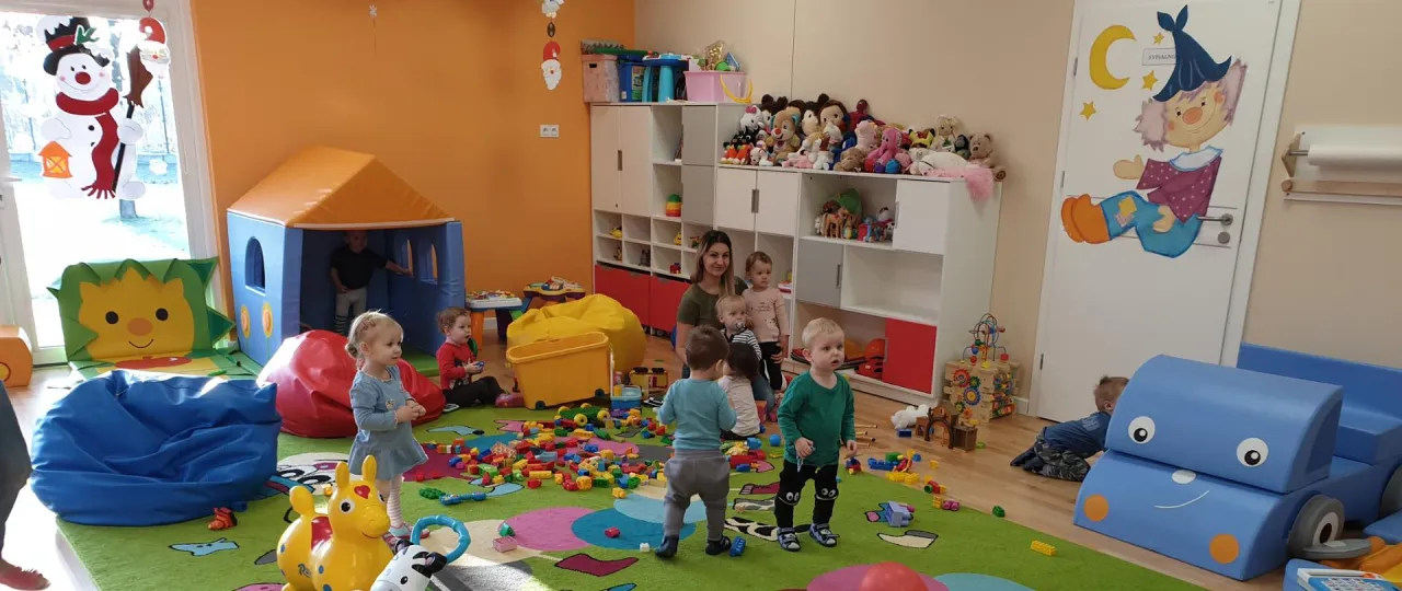Dzieci bawią się w kolorowej sali żłobkowej. Dofinansowanie do żłobka jest dostępne dla maluch&oacute;w do 3 lat.