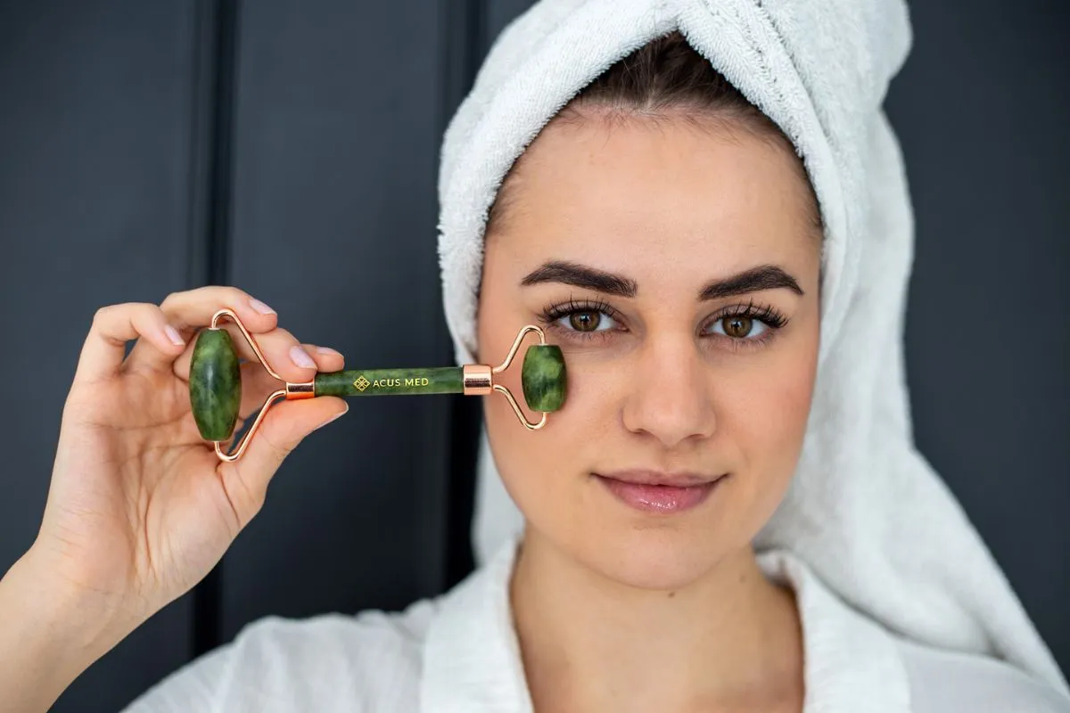 kobieta masująca twarz rollerem jadeitowym