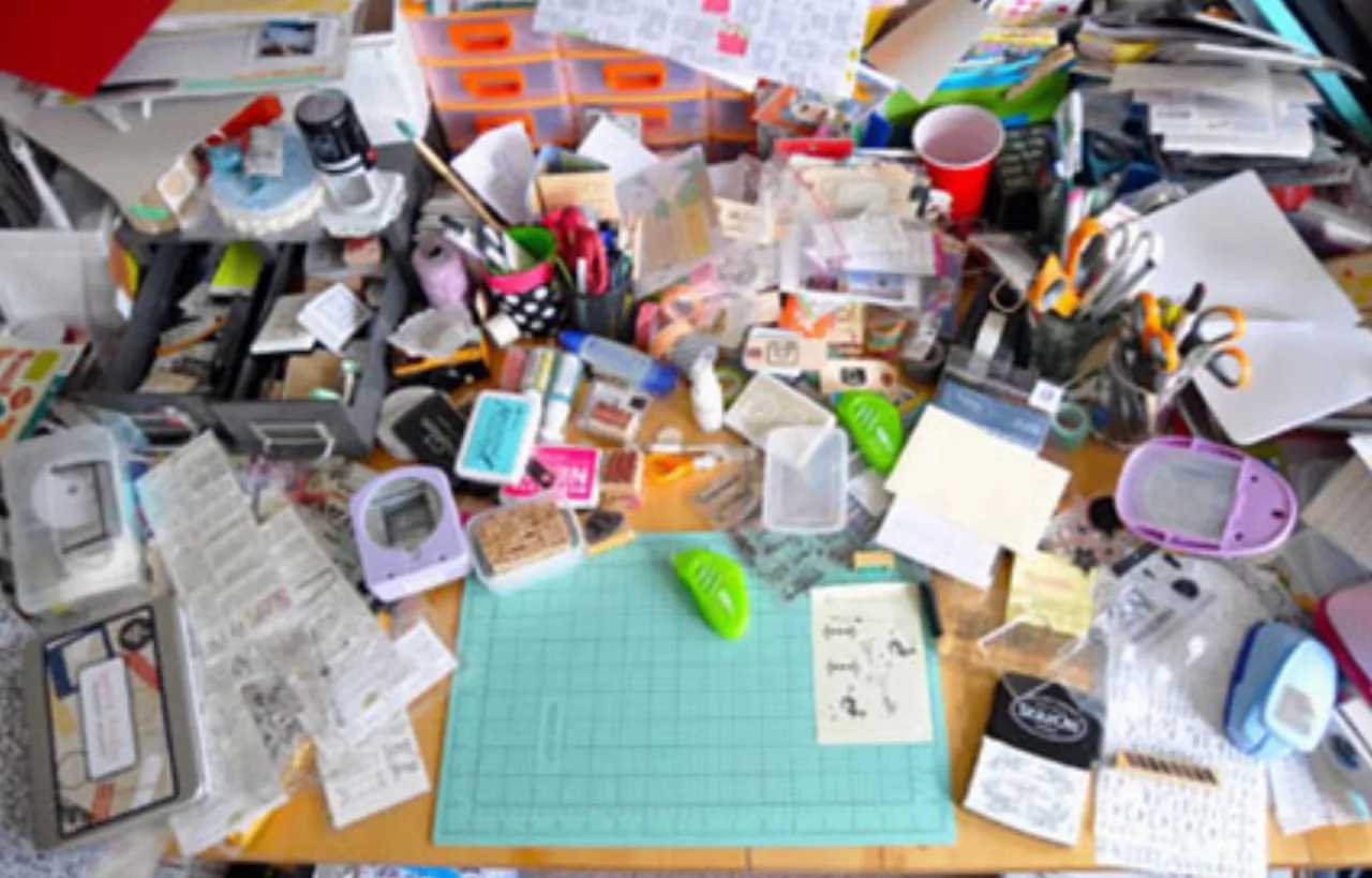 rozrzucone notatki, osoba pr&oacute;bująca się skupić, chaos na biurku