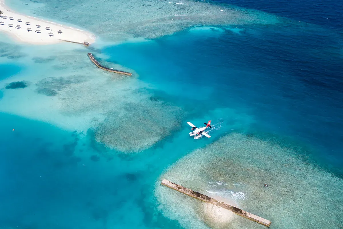Samolot wodnosamolot leci nad turkusową wodą. Zastanawiasz się, ile trwa lot na Malediwy?