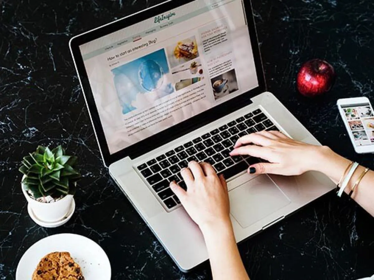 Ktoś pisze na laptopie artykuł 