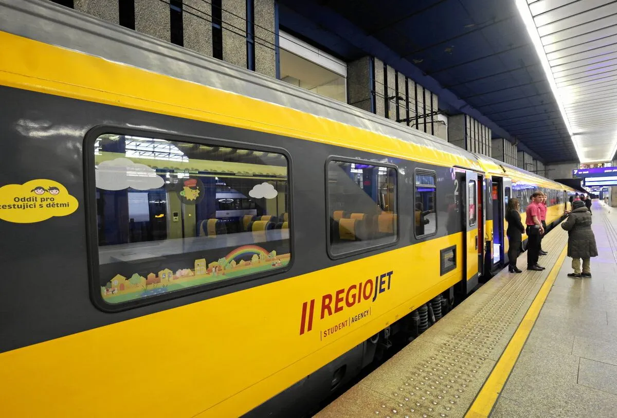 Ż&oacute;łty pociąg RegioJet na peronie. Czy można jechać wcześniejszym pociągiem regio? Pociąg ma okna z naklejkami dla dzieci.