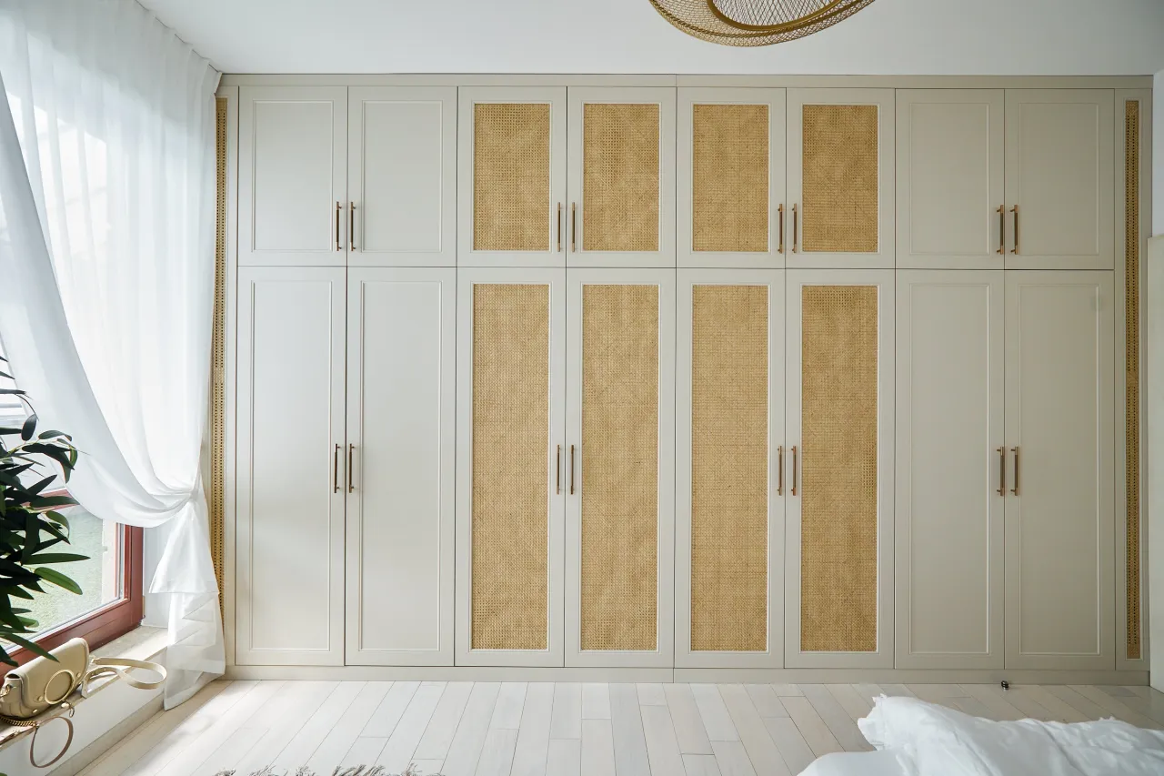 szafa z białymi drzwiczkami ażurowymi w sypialni w stylu boho