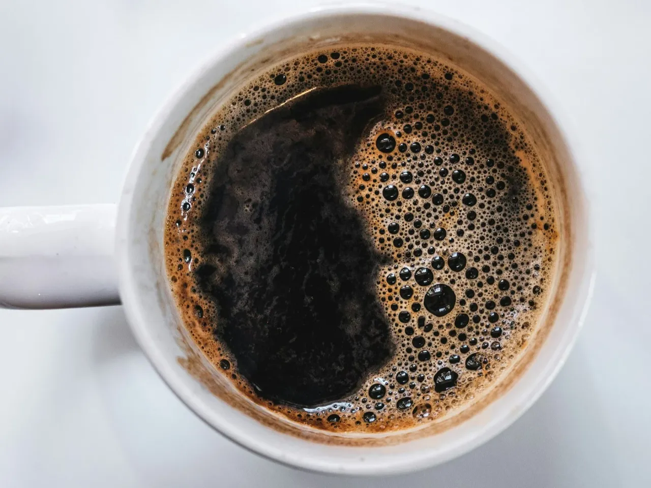 Filiżanka kawy z ziarnami, symbolizująca zdrowy nap&oacute;j z antyoksydantami