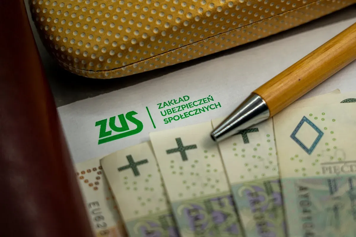 ZUS i pieniądze, długopis nad nimi. Czy nagroda jubileuszowa wlicza się do emerytury?