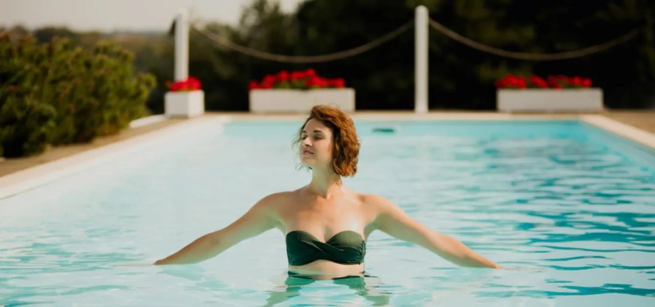 Kobieta w basenie, relaksująca się w wodzie. Idealne miejsce na tanie spa dla dwojga, by odpocząć od zgiełku.