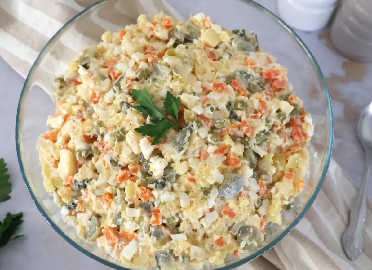 Pyszna sałatka jarzynowa w szklanej misie, pełna warzyw i jajek. Czy jest zdrowa? Zależy od dodatków!