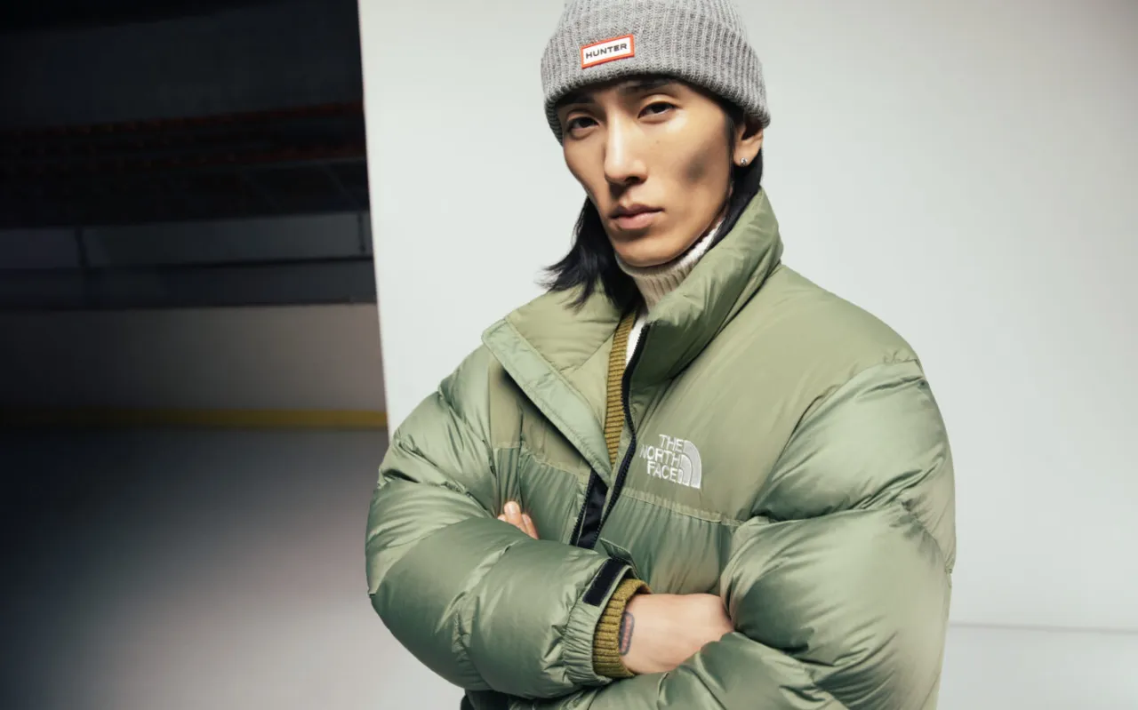 Mężczyzna w zielonej kurtce puchowej, czyli kurtce puffer, co to znaczy? To ciepła, obszerna kurtka z wypełnieniem.