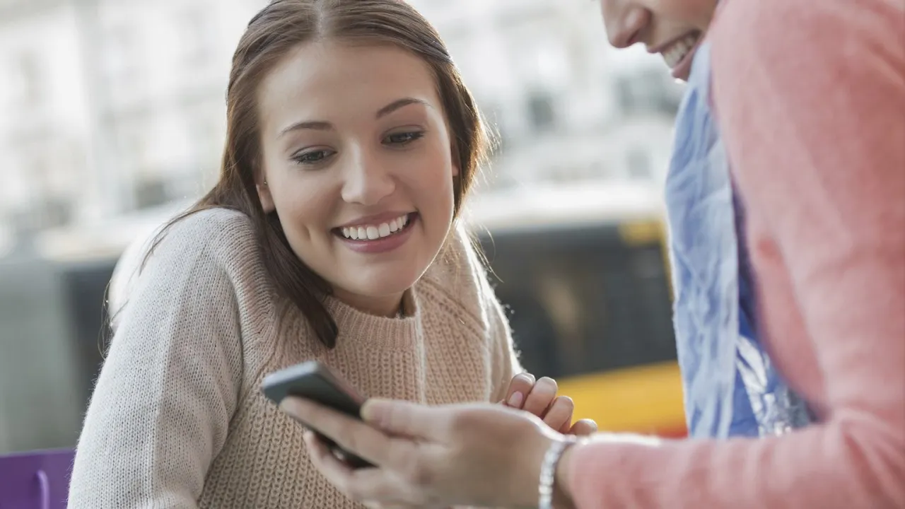 Mężczyzna i kobieta piszący wiadomości na smartfonach po randce, z uśmiechem