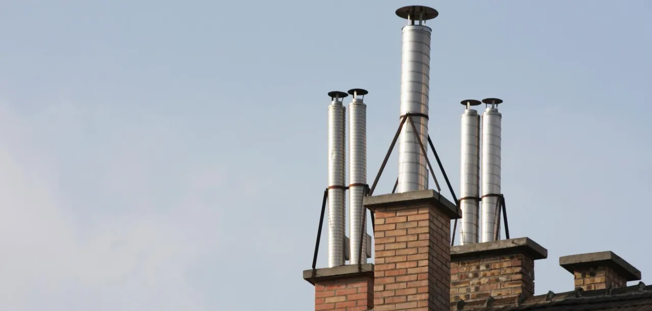 Nowe wkłady kominowe w starym kominie. Metalowe rury zamontowane na ceglanych kominach, gotowe do użytku.