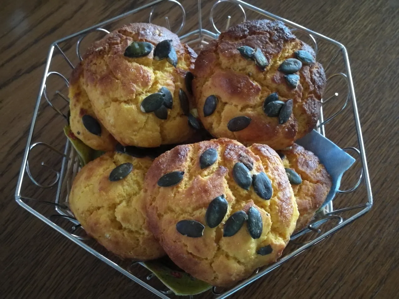 Bułeczki kukurydziane bezglutenowe, posypane pestkami dyni, gotowe do podania. Idealne na śniadanie lub przekąskę.