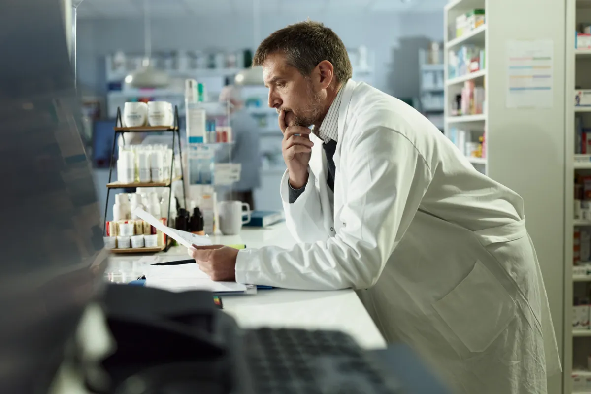 Farmaceuta analizuje dokumenty, zastanawiając się, jaki lek na cukrzycę jest wycofany.