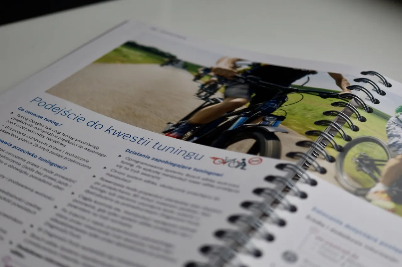 Instrukcja omawia jak odblokować rower elektryczny, pokazując dynamiczne zdjęcie rowerzysty na ścieżce.